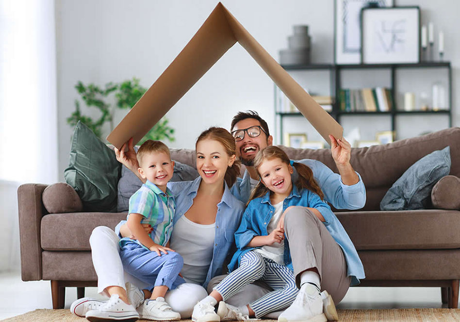 happy family sitting in living room with cardboard roof over them